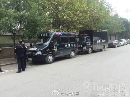 校门口围着大批居民,多辆警车进入学校处理此事。现场图片