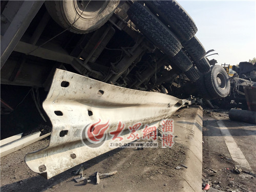 側翻的半掛車“橫跨”在了路中間的護欄上