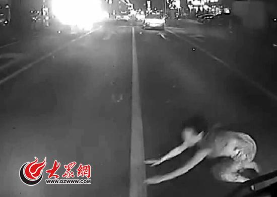 女子突然從路邊跑出，趴在一輛66路公交車前。