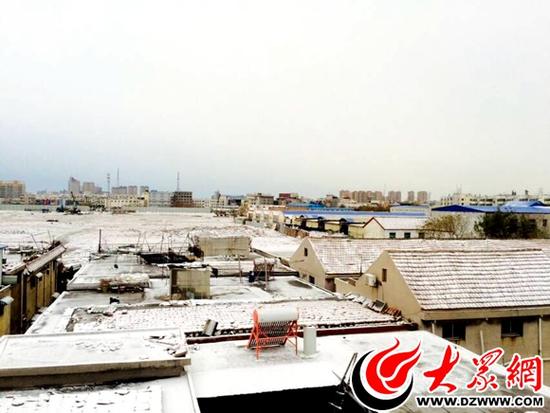菏泽:21日晚,薄雪一层覆盖屋顶