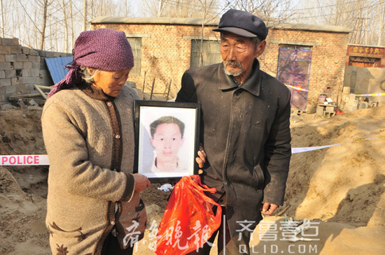 老兩口抱著兒子的遺像,悲痛不已。齊魯晚報·齊魯壹點 記者 鄒俊美 張蔚 攝