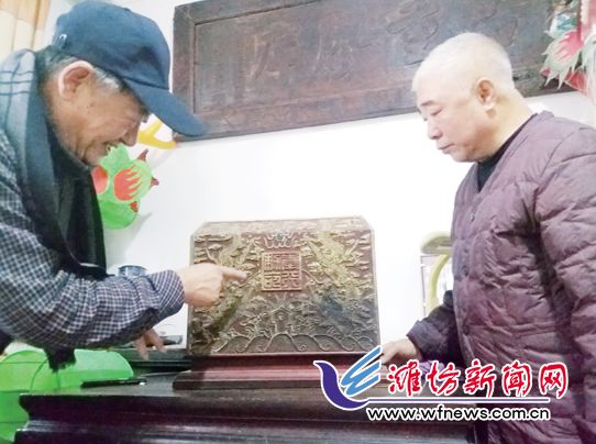 劉寶生(右)展示他家珍藏的圣旨盒。