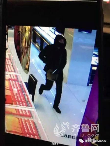 一名身穿黑色衣服的男子將自己包裹的嚴嚴實實后走進了這家金店