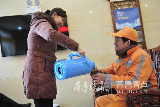 27日,濟南天下第一泉景區趵突泉游客服務中心,清潔工王玉樓進門來暖暖手腳。(齊魯晚報·齊魯壹點記者 周青先/攝)
