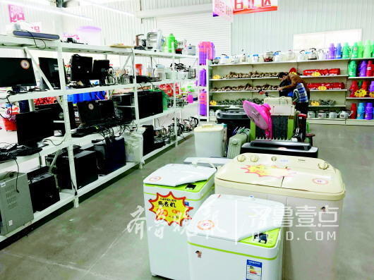 在沂南县社会组织服务中心“爱心超市”,洗衣机只卖20元。图为包村干部在爱心超市用爱心款给贫困户购物。 记者 陈玮 摄