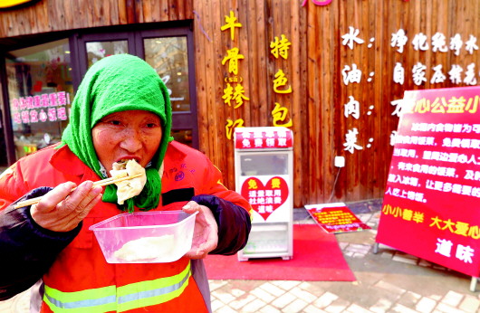 在附近工作的环卫工刘殿英经常会来取一份爱心餐食用。