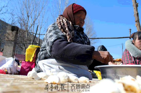 陈庆坤83岁的母亲，从18岁起就在摊子上包包子。