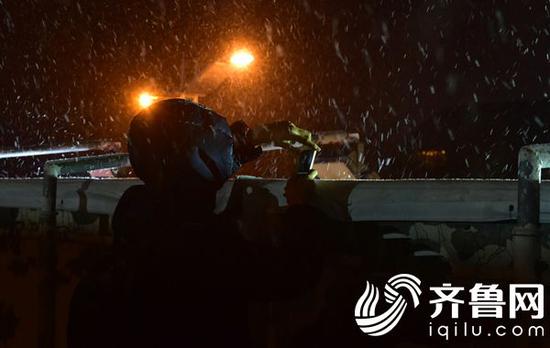 21日18时许，济南一市民用手机拍照记录降雪的到来。（张伟 摄）