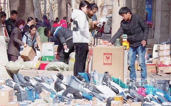 20日,在山东师范大学校园内,学生正在取快递。大学校园是各快递企业之间竞争的重要战场之一。齐鲁晚报·齐鲁壹点 记者周青先摄