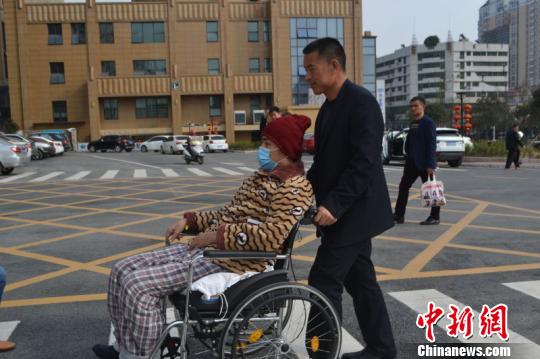 白天沒有治療安排的時候,邵新運也會推著輪椅帶親家公吉書華去外面轉悠曬太陽。 吳鵬泉 攝
