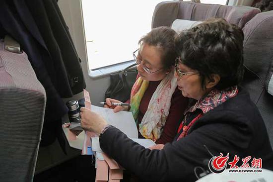 3月2日下午，出席十二届全国人大五次会议的住鲁全国人大代表在赴京列车上认真讨论准备向大会提交的建议。大众网特派记者 王长坤 摄