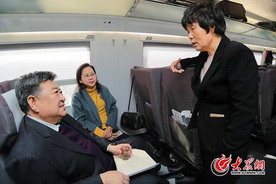 3月2日下午，出席十二届全国人大五次会议的住鲁全国人大代表在赴京列车上认真讨论准备向大会提交的建议。大众网特派记者 王长坤 摄