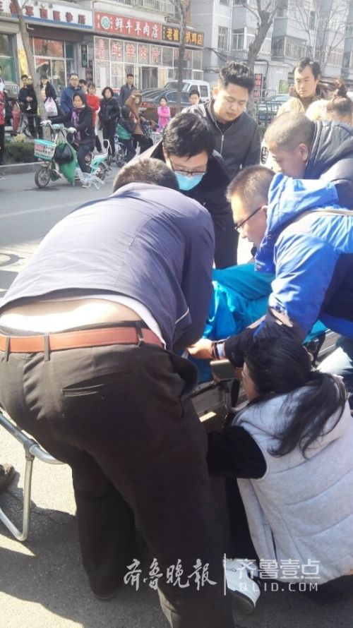 围观路人合力将孩子抬上了救护车(齐鲁晚报·齐鲁壹点记者 刘振)