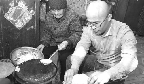 房东大娘烙煎饼,朱观景帮忙打下手。齐鲁晚报记者 高翔 邱明 摄