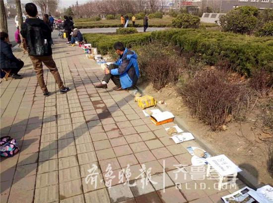不少市民拿來盒子、板凳、水桶等物品排隊。 齊魯晚報·齊魯壹點 記者 時培磊 攝