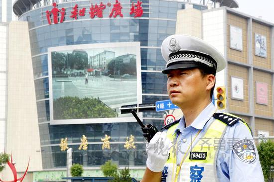 22日,經十緯十二路交口附近的大屏幕上,滾動播出非機動車和行人亂闖紅燈影像視頻。齊魯晚報·齊魯壹點 記者 左慶 攝