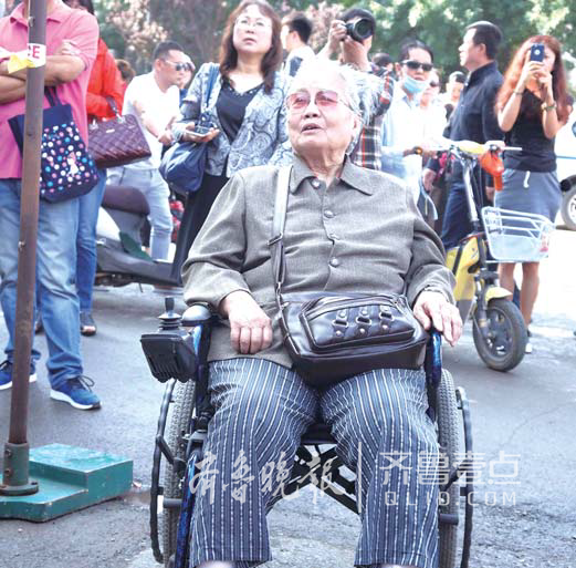 一名78歲的老人自己坐輪椅來(lái)到省實(shí)驗(yàn)中學(xué)考點(diǎn)，看著自己的孫子進(jìn)考場(chǎng)。