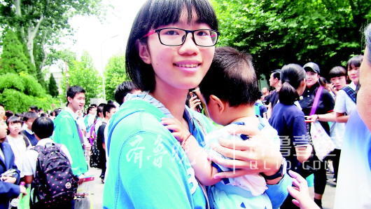 11日,山師附中考場,7個月的小二寶跟父母一起來迎接姐姐。