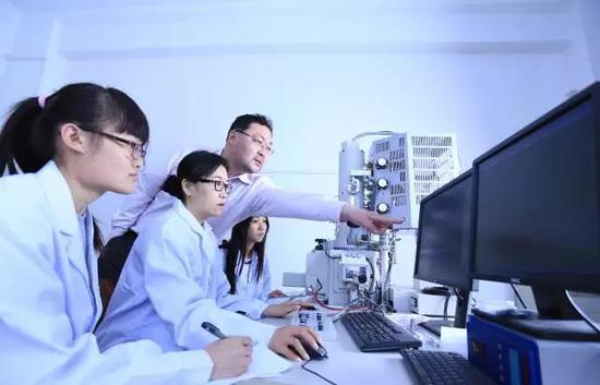 教授正在指导研究生做实验