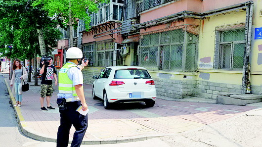 济南纬一路，交警对违停车拍照取证。齐鲁晚报记者 张泰来摄