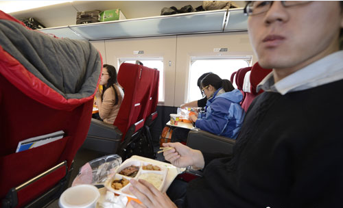　图为G801次列车一等座席的乘客在品尝列车提供的餐食。中新社发 侯宇 摄
