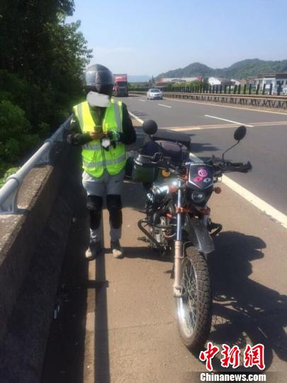 图为：“90后”研究生在沈海高速公路上演“千里走单骑”。　王信　摄