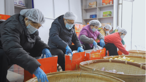 图为牛继林与村民一起打包春节放心馒头