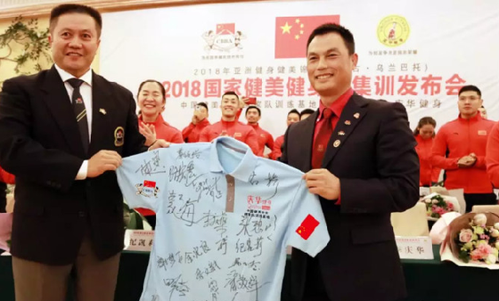 古桥秘书长代表国家队向训练基地委员会主任李庆华赠送纪念版国家队签名战衣。 