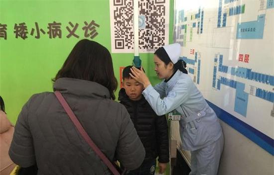 菏澤市立醫(yī)院醫(yī)護人員為孩子測量身高