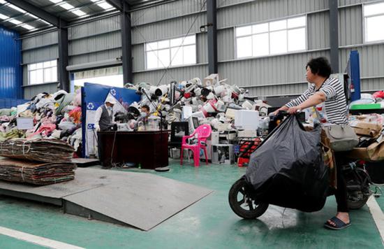 一位居民将自己日常收集的可回收物送到上海闵行区浦锦街道的“两网融合”中转服务站(5月27日摄)。新华社记者 方喆 摄