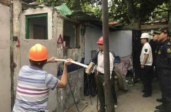图说:虹口城管在拆除违法建筑。宏新摄(下同)