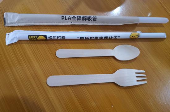 依次为PLA全降解吸管、快乐柠檬纸吸管、肯德基木质勺和叉
