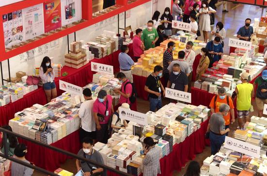 8月12日,读者在位于上海展览中心的2020上海书展主会场上选购图书。新华社记者 任珑 摄