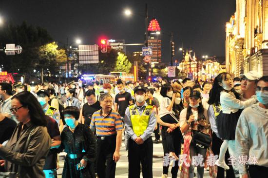 图说:10月1日晚,外滩的执勤民警在人流中坚守岗位。杨建正 摄