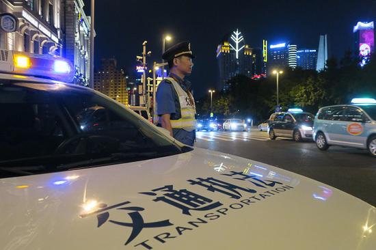 图说:执法人员在外滩沿线执法、执法人员查处黑色“亮灯”“黑车” 市交通委执法总队供图(下同)