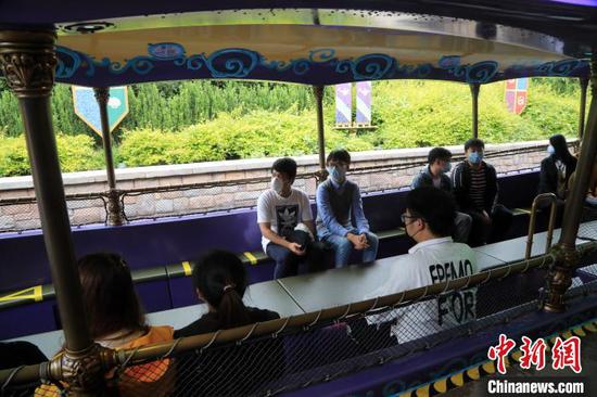 在上海迪士尼乐园游乐设施上，非同行游客之间将留出一个空位，以进一步保持安全距离。　汤彦俊 摄