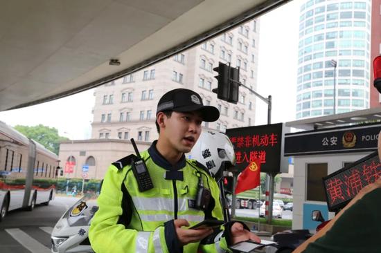 黄浦民警给违法行人开具罚单。 黄浦警方供图