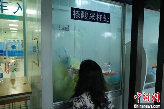 检测采样人员可以在相对密闭的核酸采样处，通过采样口进行采样操作。　戴文仪 摄