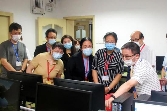 工作人员向考生家长介绍评卷技术保障和校验情况