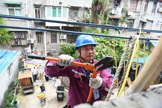 国网上海电力抢修人员为普善路铁路新村居民更换老旧进户线 图片来源:国网上海电力