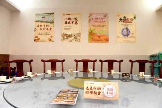 图说:在餐饮店张贴关于“宜起来”节约宣传海报,倡导大家争当“光盘族”。街道供图