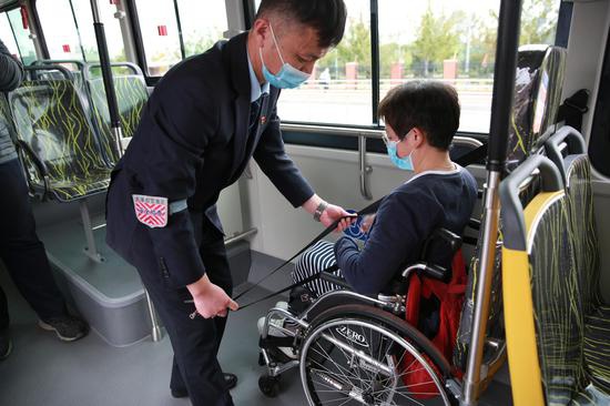 久事公交集团的驾驶员展示进博会接驳公交线“白金刚”的无障碍设施操作流程。王雨青 图