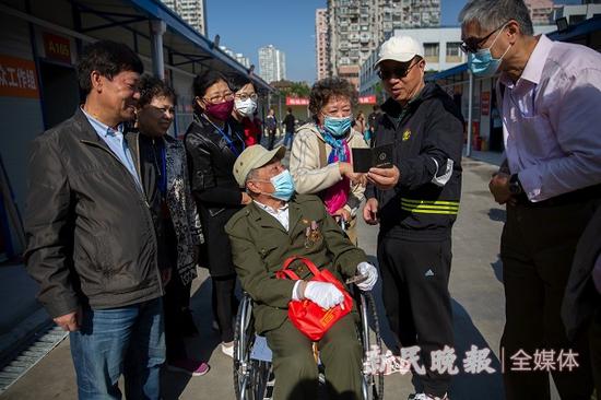 图说:季荣坤和老伴杨建民第一个完成货币签约
