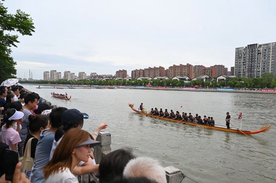 2026年6月19日,市民和游客聚集在泗泾塘边小区的滨水步道,观看端午龙舟赛。澎湃新闻记者 吴栋 图