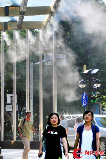 图说:尽管已过处暑节气,早晚时段已渐凉,但申城白天街头行走的路人明显感到“热度不减”。 杨建正摄