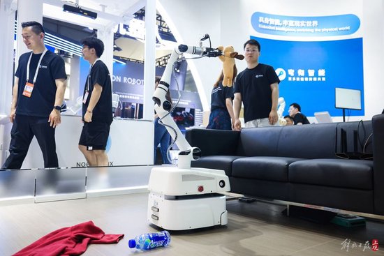 上海穹彻智能科技展台内,工作人员使用自适应机器人进行一系列技术展示。
