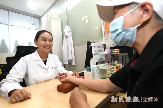 图说:龙华医院汤康敏医生为患者把脉 新民晚报记者 徐程 摄