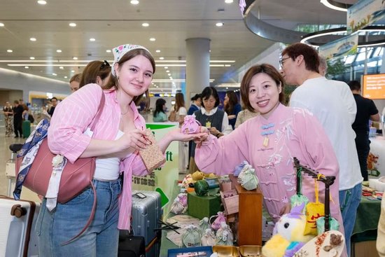 工作人员向外国旅客介绍中国传统香囊