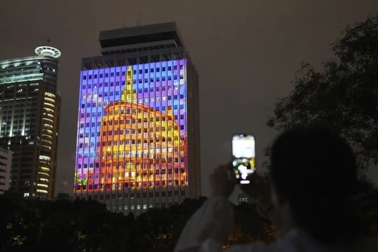 市民举起手机记录这幢楼的“新装”