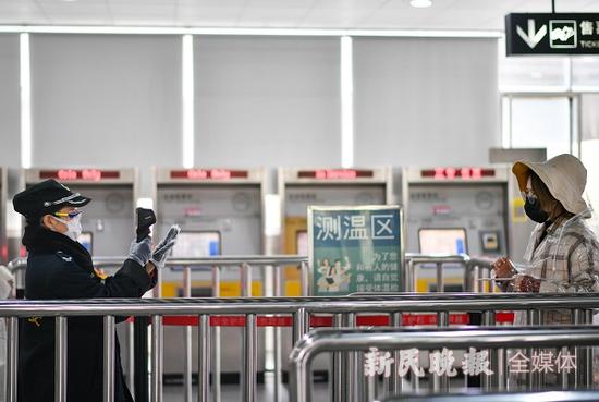 图说:入站乘客必须经过体温检 陈梦泽 摄